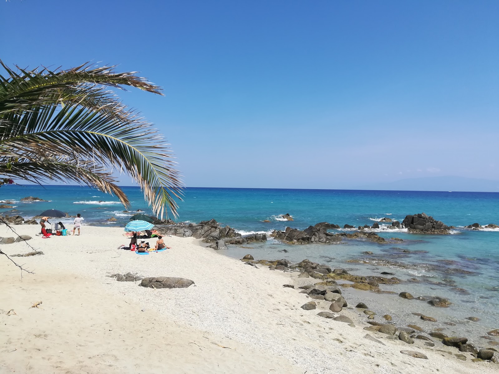 Foto von Punta scrugli beach mit blaues wasser Oberfläche