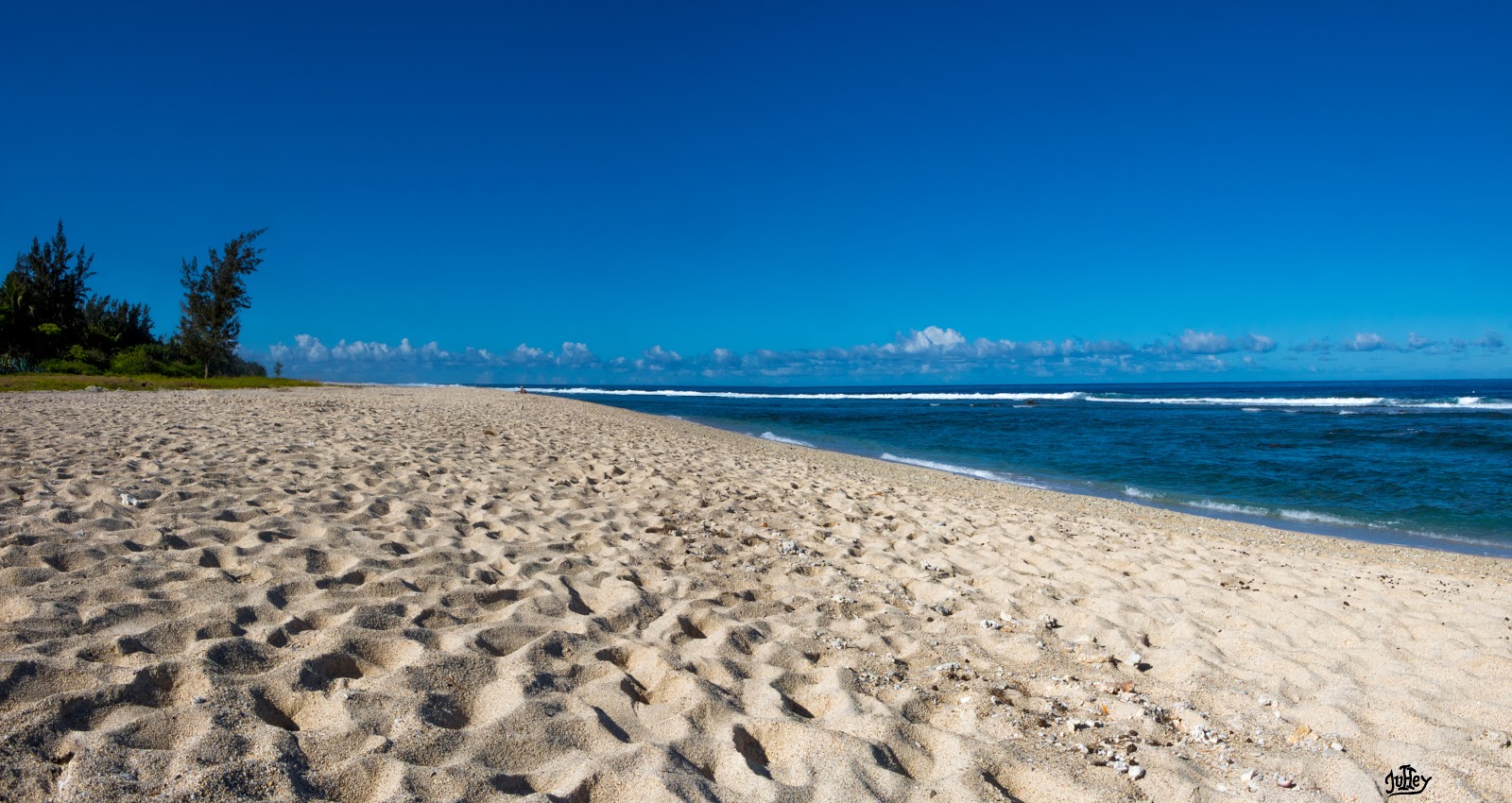 Breaking Beach的照片 带有明亮的沙子表面