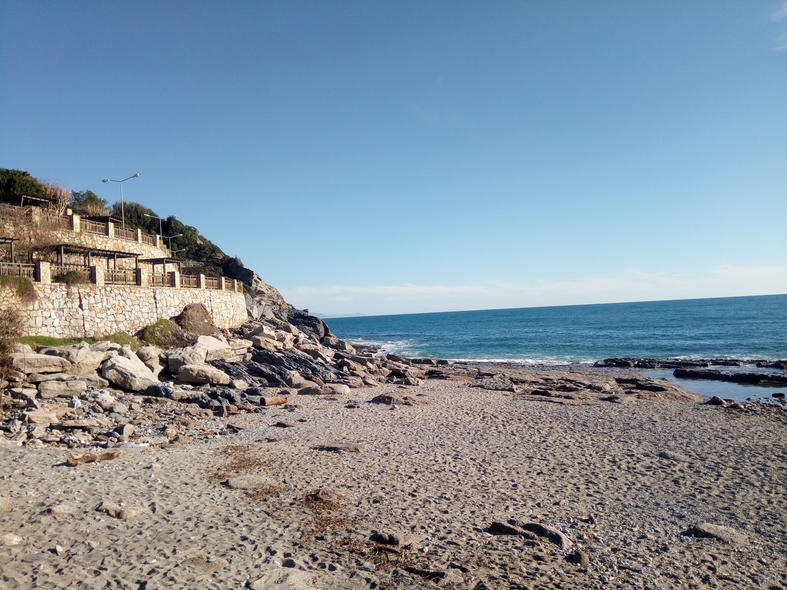 Φωτογραφία του Dinek beach υποστηρίζεται από βράχους