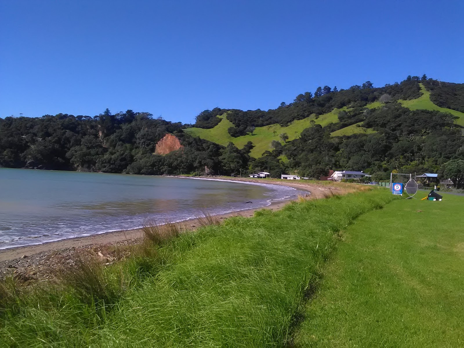 Foto de Sandy Bay Beach com areia bege e seixos superfície