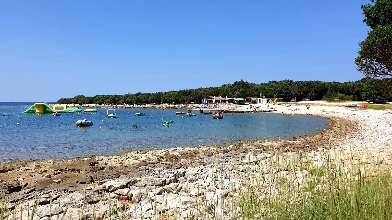 Foto di Meneghetti beach con una superficie del ciottolo leggero