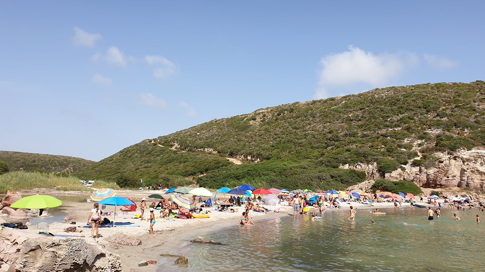 Foto di Spiaggia Cala Lunga circondato da montagne
