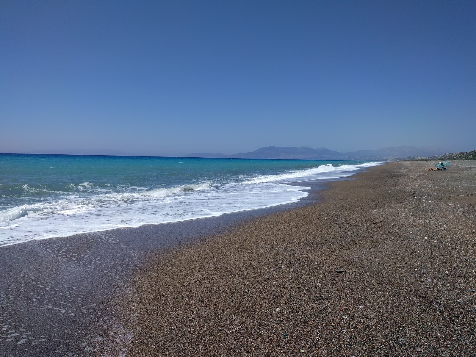 Φωτογραφία του Wild beach με μαύρη άμμος και βότσαλα επιφάνεια