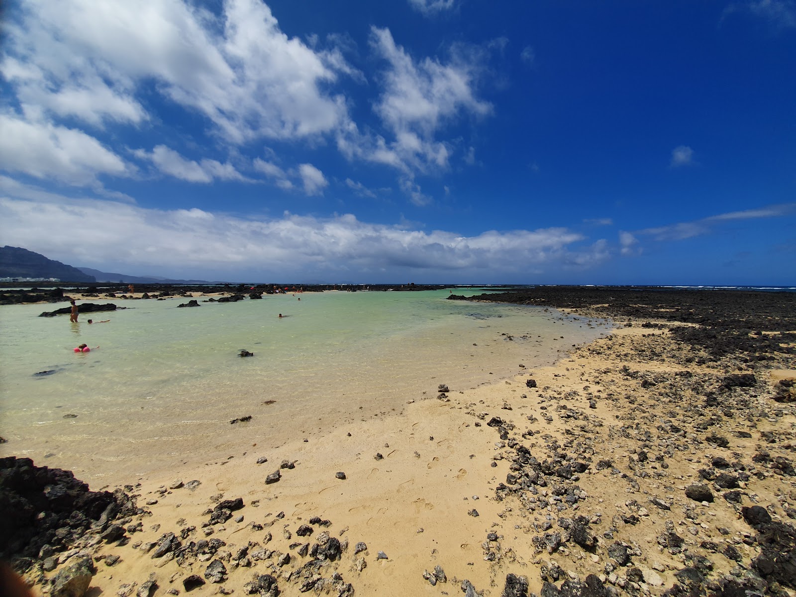 Φωτογραφία του Caleton Blanco με φωτεινή άμμος και βράχια επιφάνεια