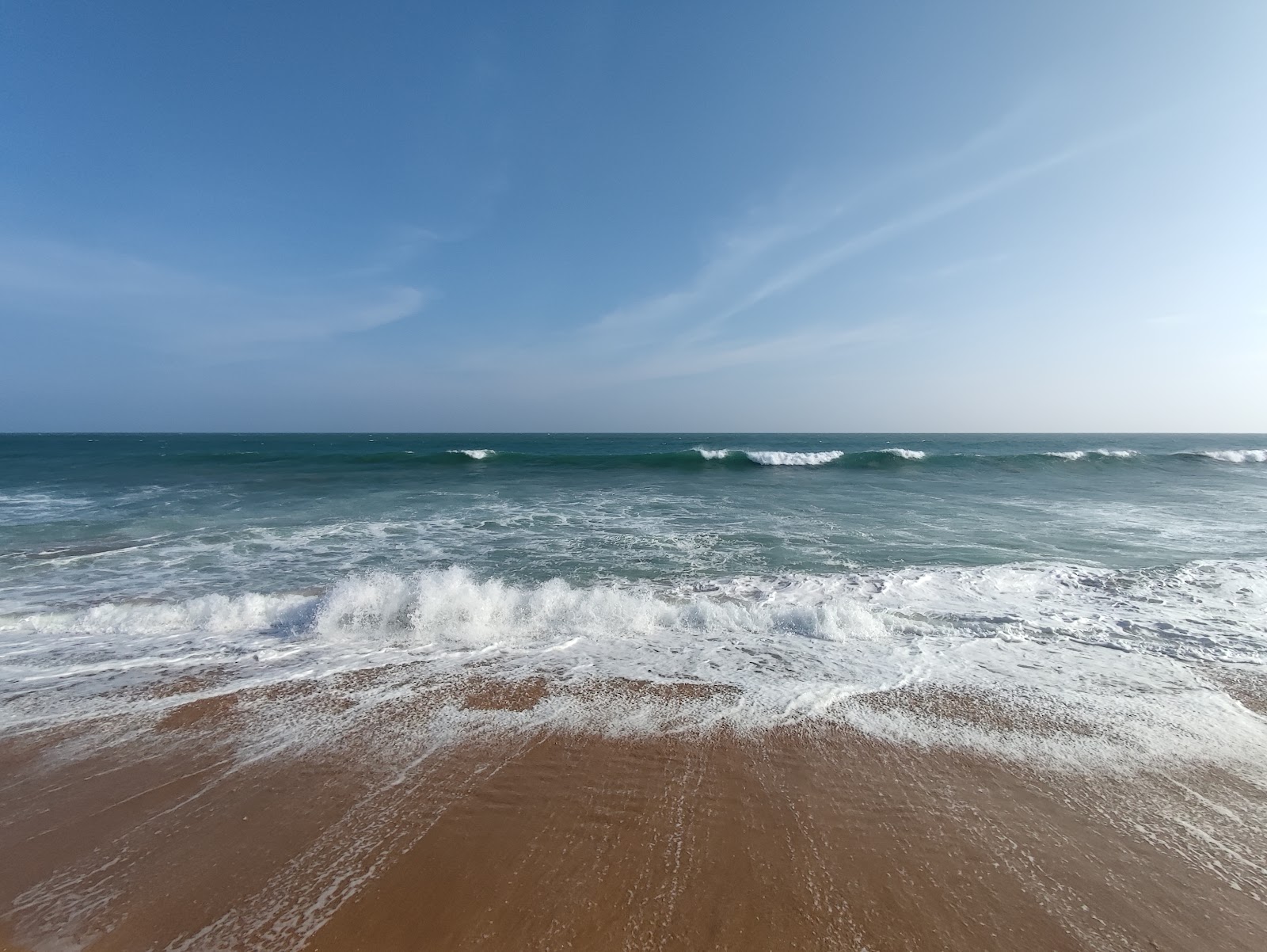 Valokuva Kundal Beachista. pinnalla kirkas hiekka:n kanssa