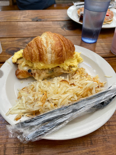 Egg, bacon, and cheese breakfast croissant with hash browns  