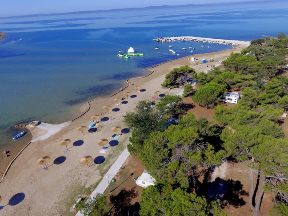 Valokuva Dalmatia beachista. pinnalla kirkas hiekka:n kanssa