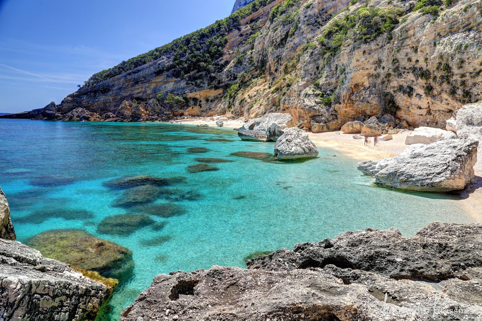 Fotografija Cala Mariolu z beli fini kamenček površino