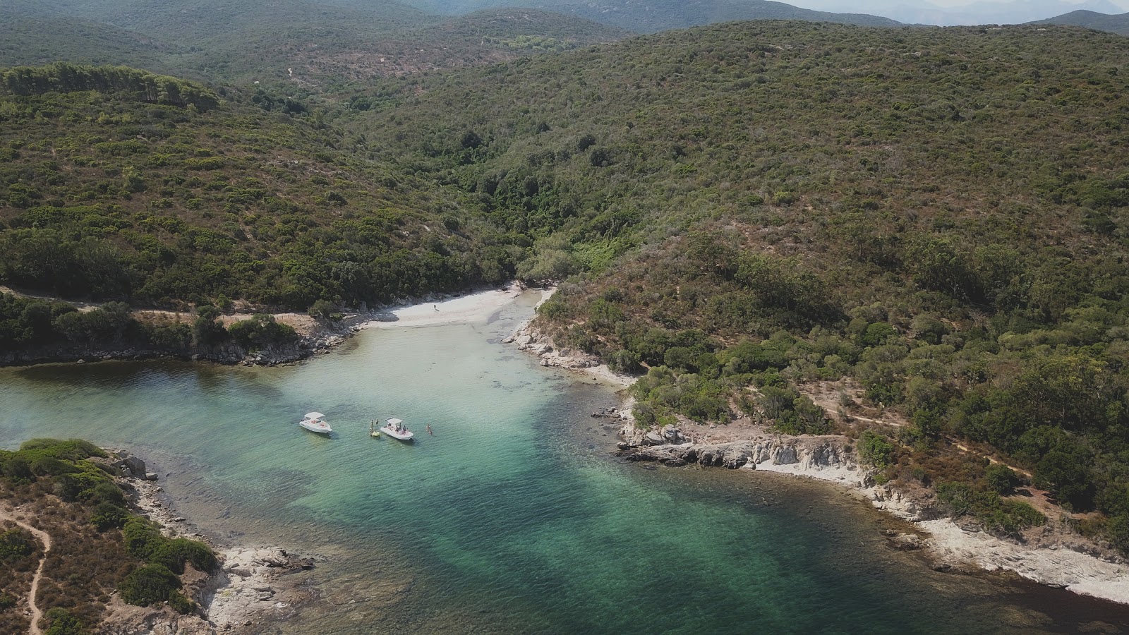 Foto di Malfalcu Cove con una superficie del sabbia grigia
