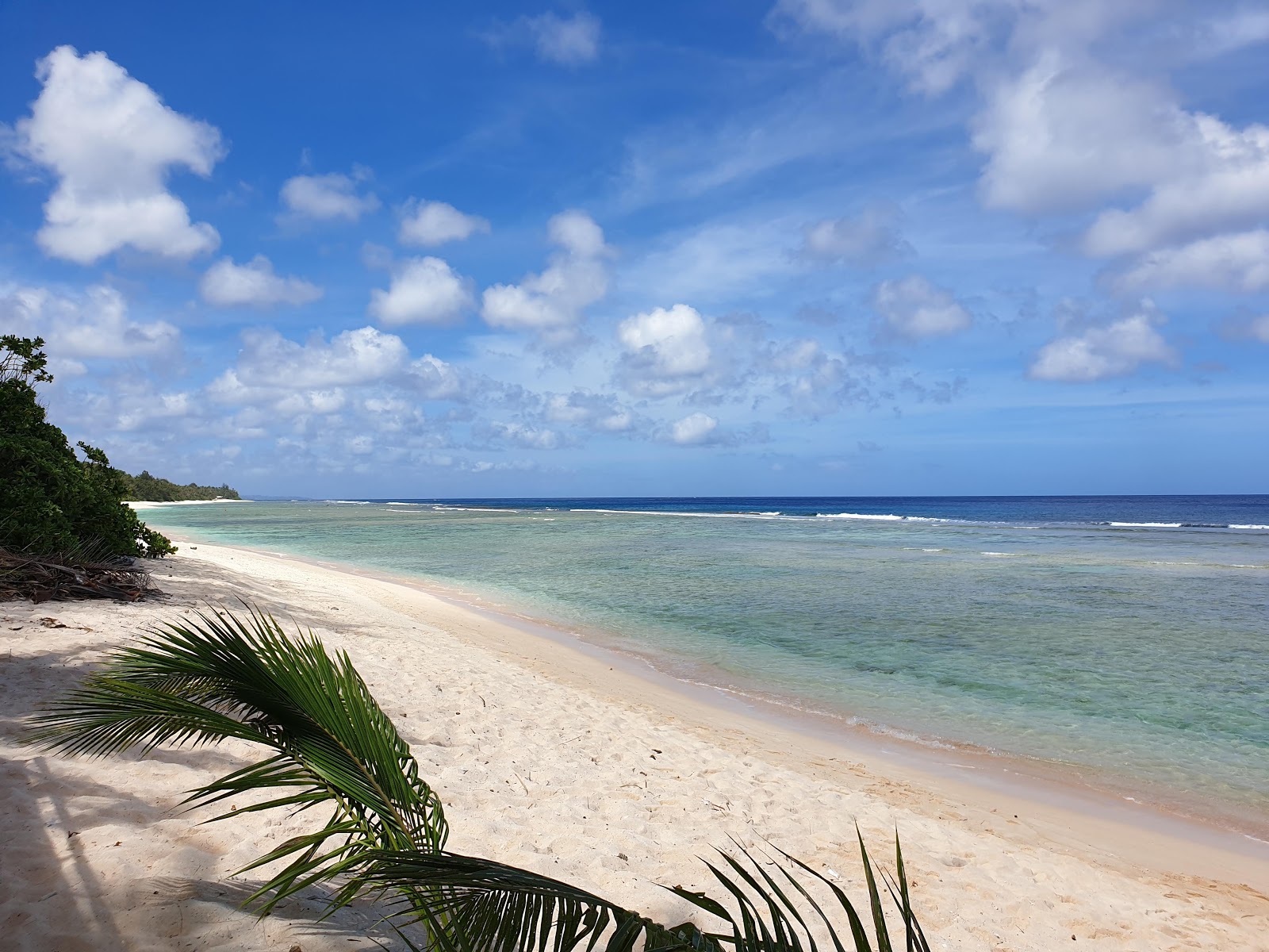 Foto van Guam Star Sand met helder zand & rotsen oppervlakte