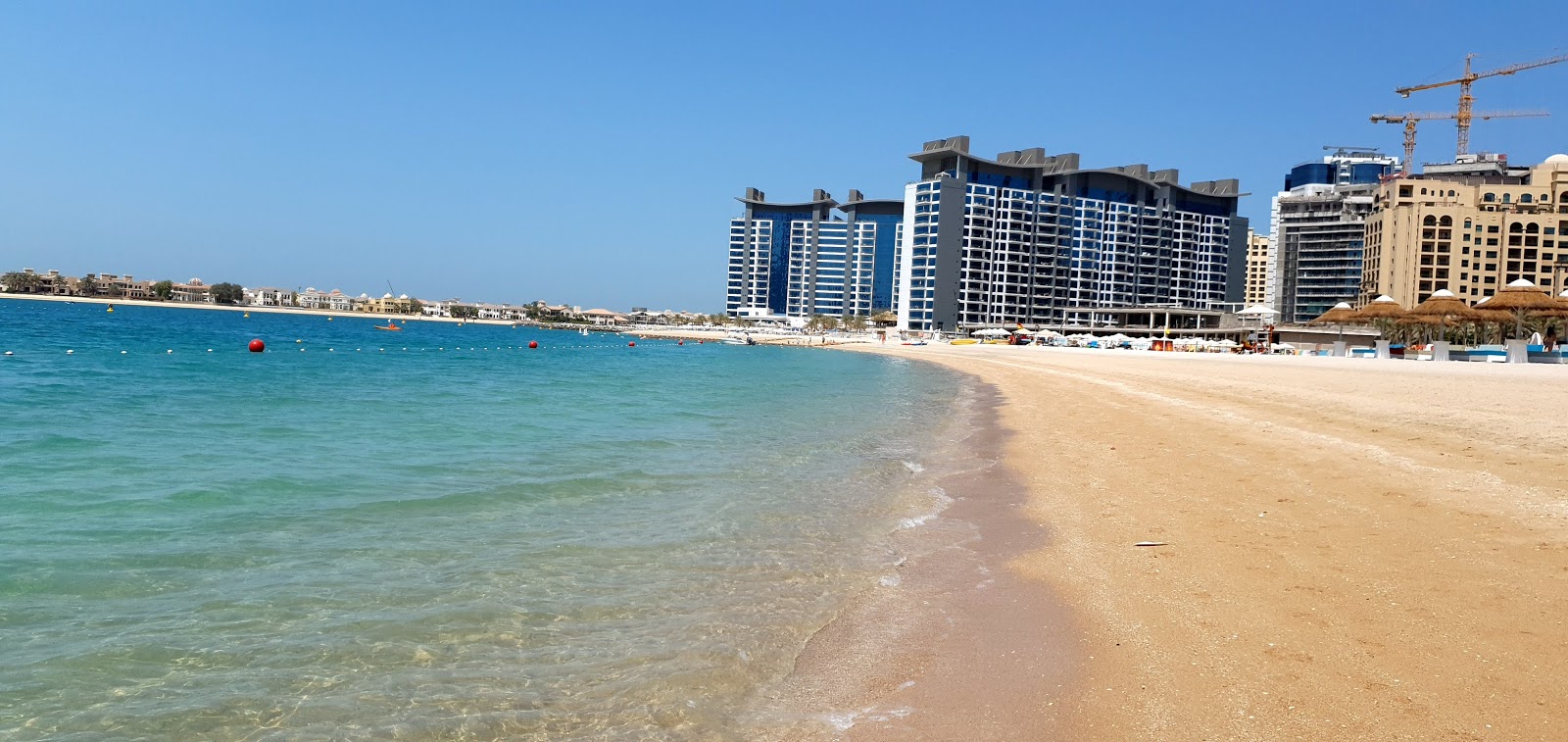 Foto di Spiaggia di Palm West con costa lunga e dritta
