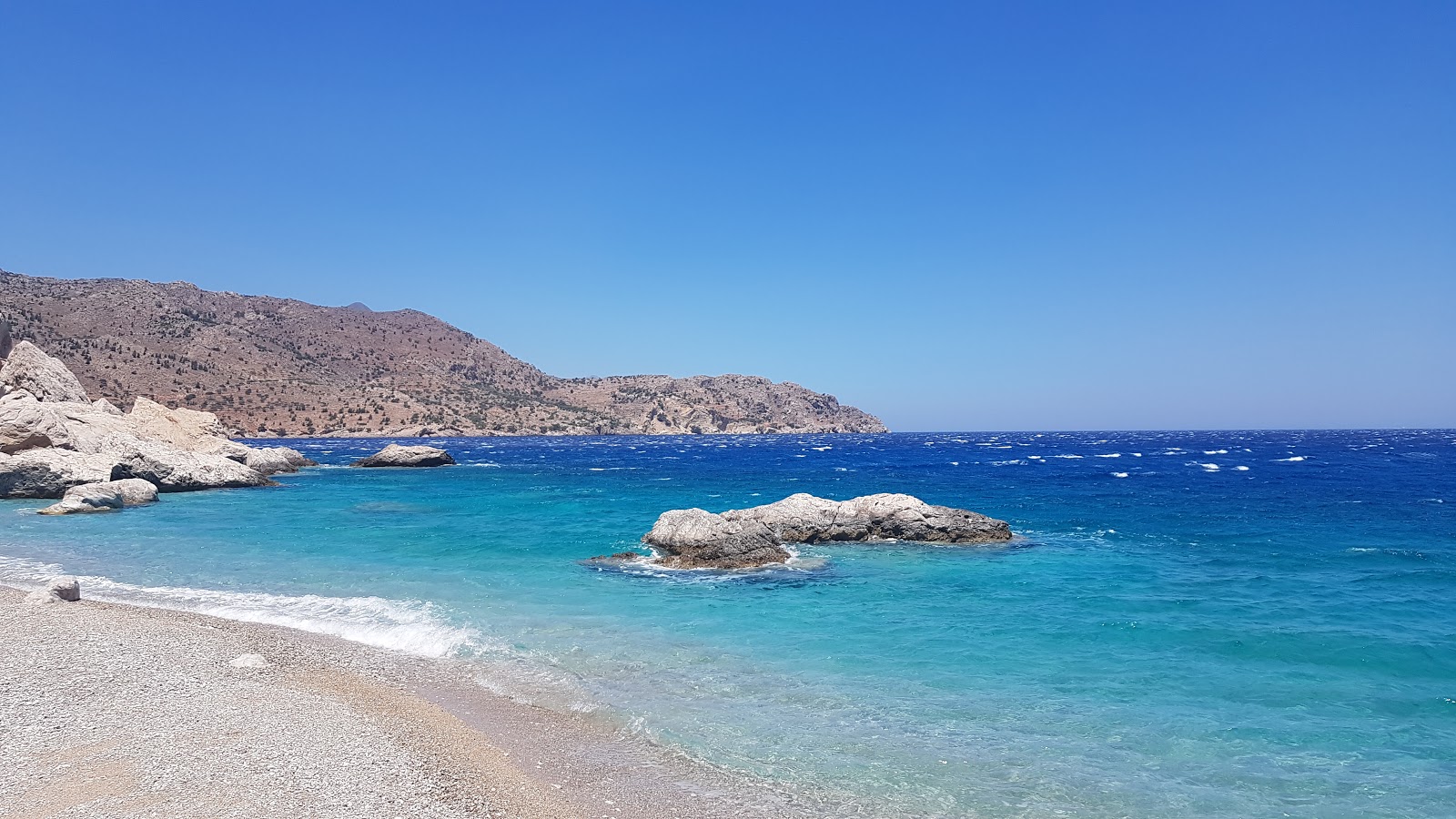 Foto van Evangeline beach ondersteund door kliffen