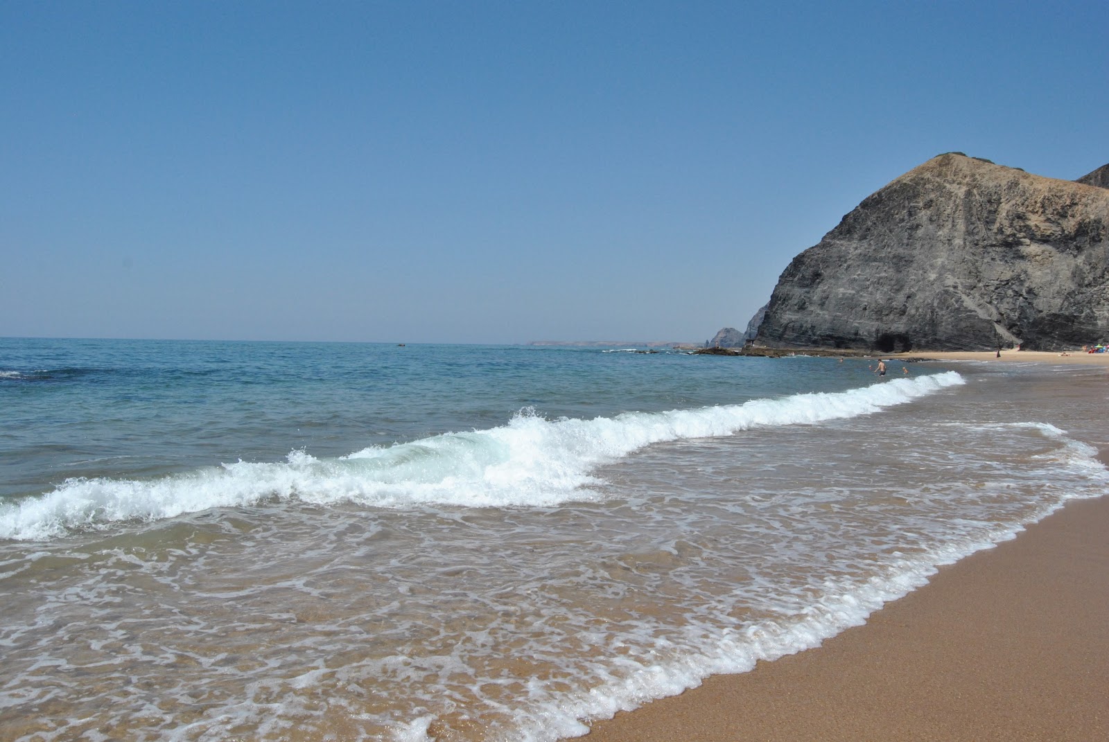 Photo of Barriga Beach backed by cliffs