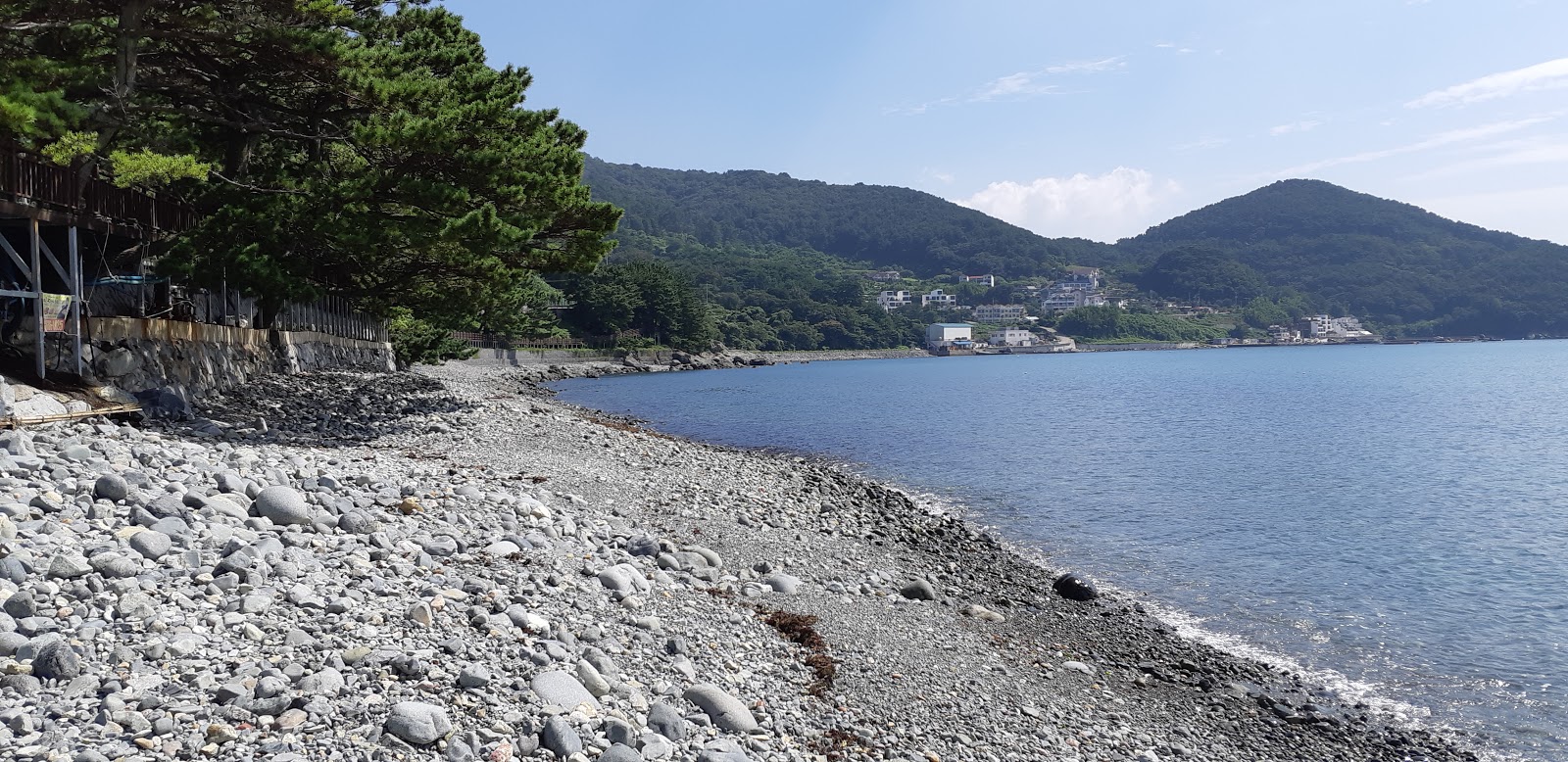 Foto von Hakdong Black Pearl Beach von Klippen umgeben