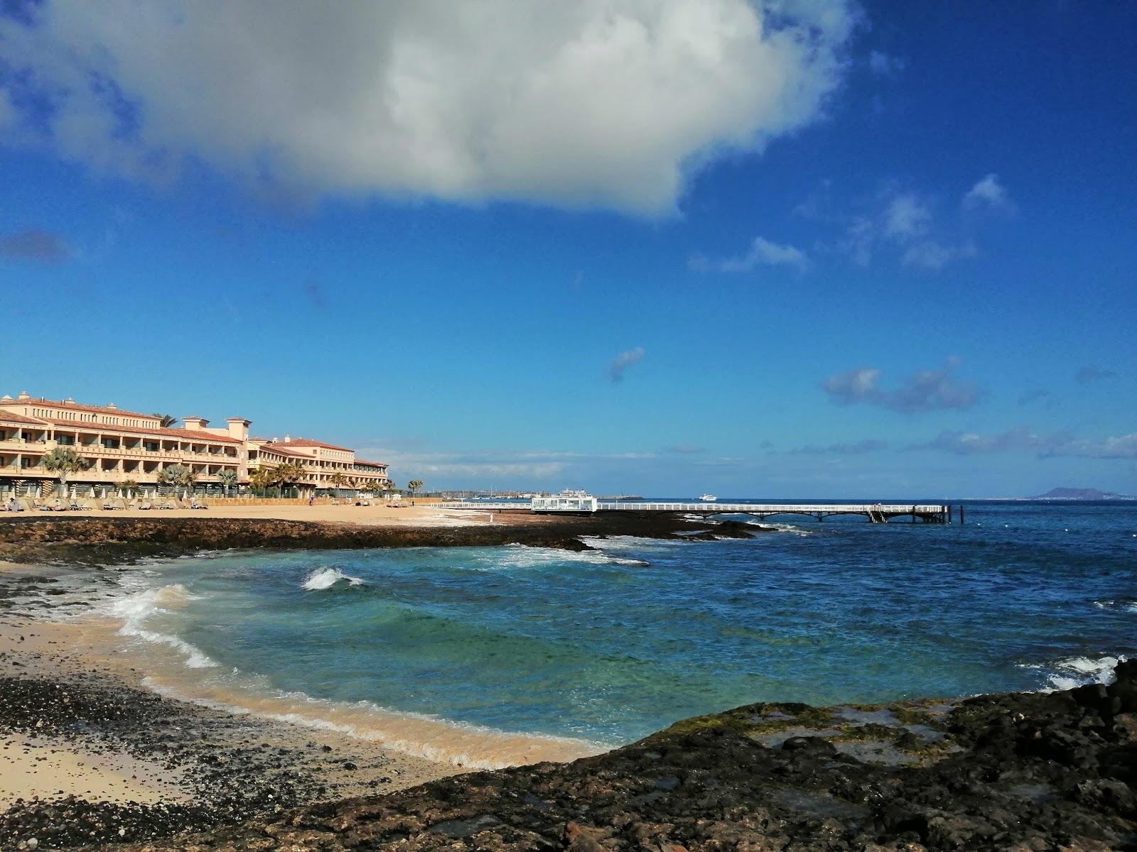 Foto de Playa Puerto Remedios con arena brillante y rocas superficie