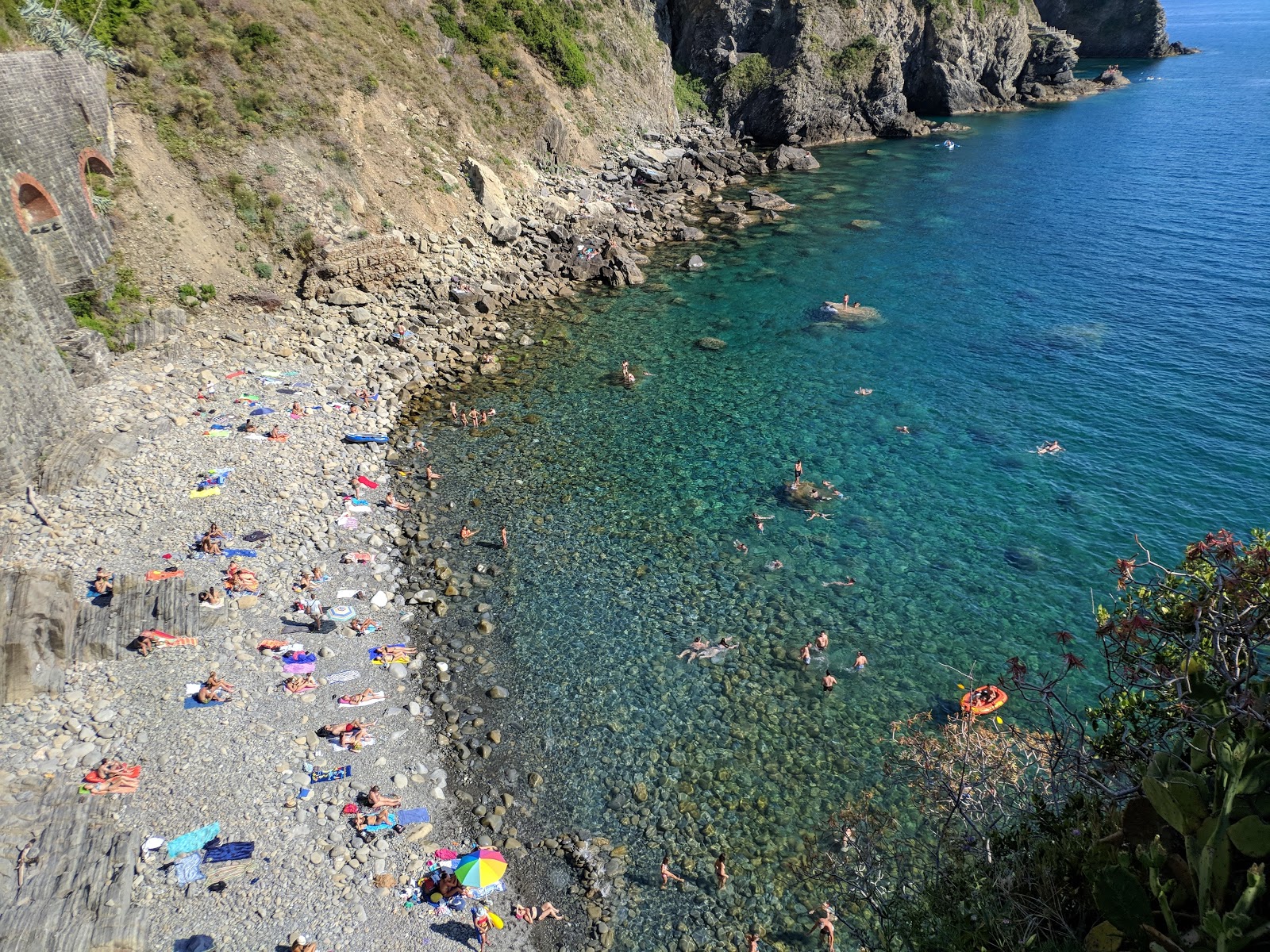 Foto von Strand von Riomaggiore mit blaues wasser Oberfläche