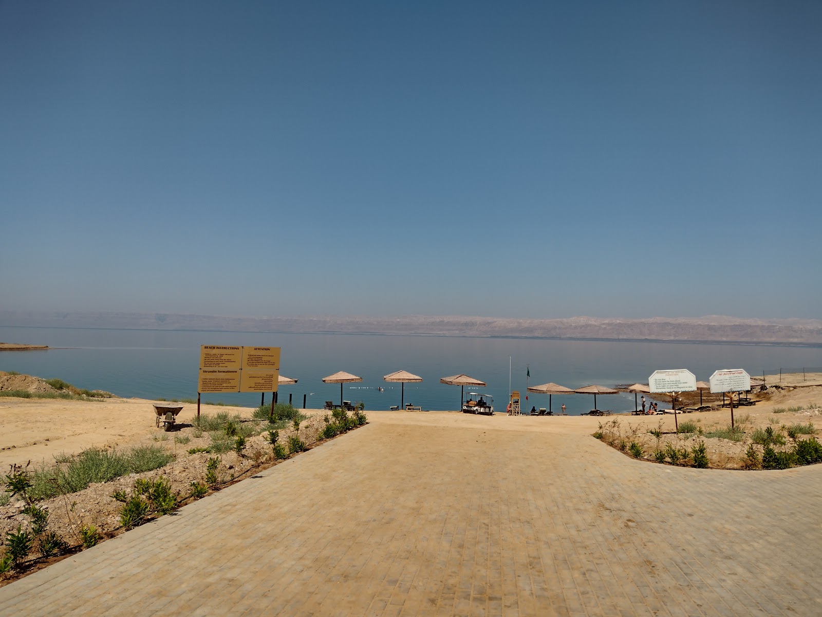 Foto av Dead Sea Beach med musta hiekka ja kivi yta