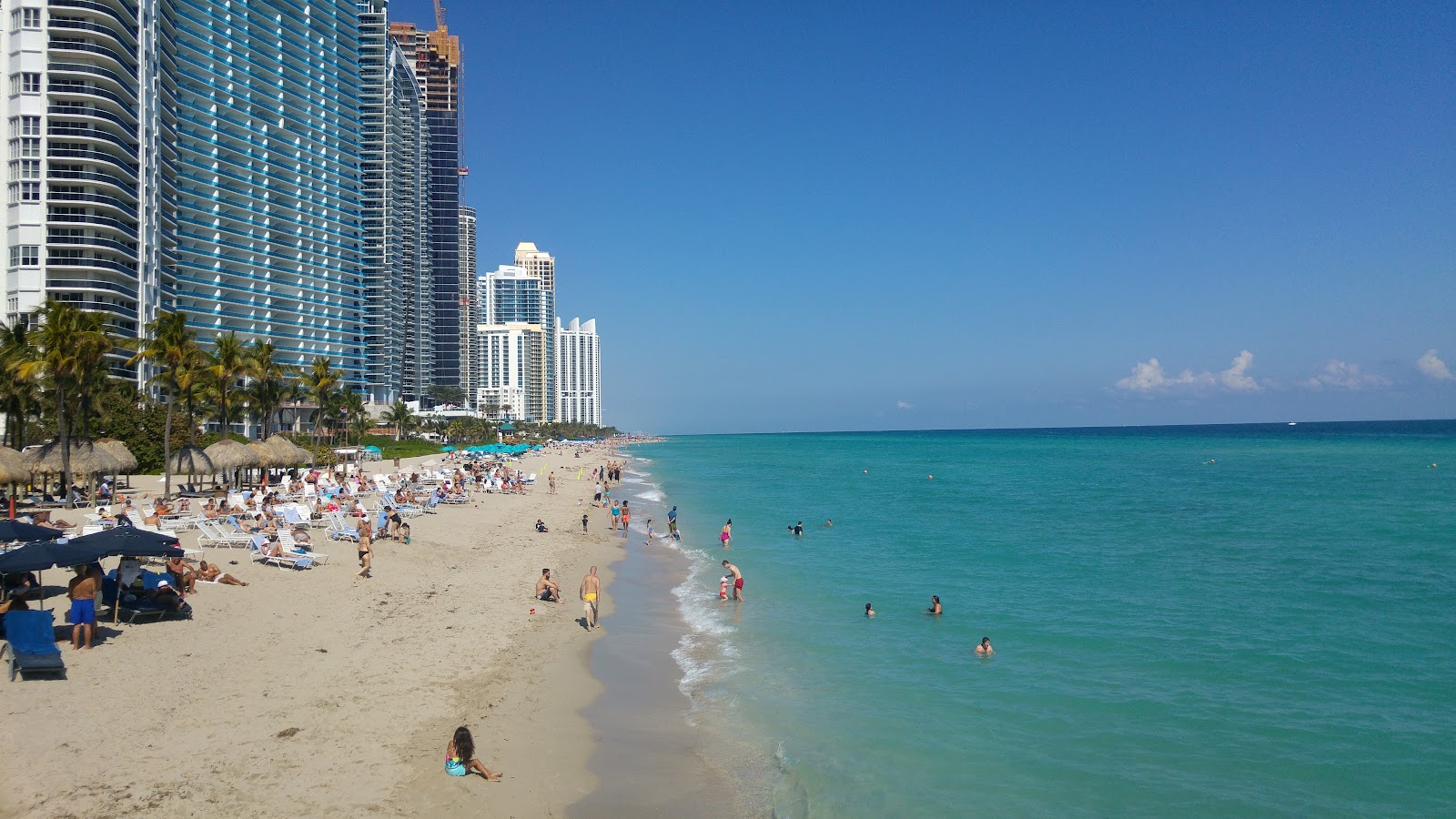 Foto di Spiaggia di Sunny Isles con una superficie del sabbia di conchiglie beige