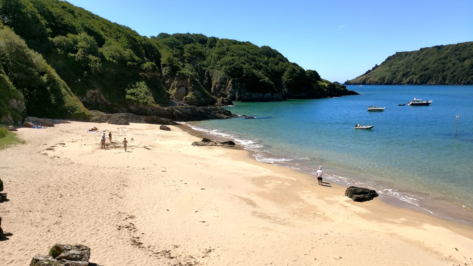 Photo of Sunny cove beach with bright fine sand surface