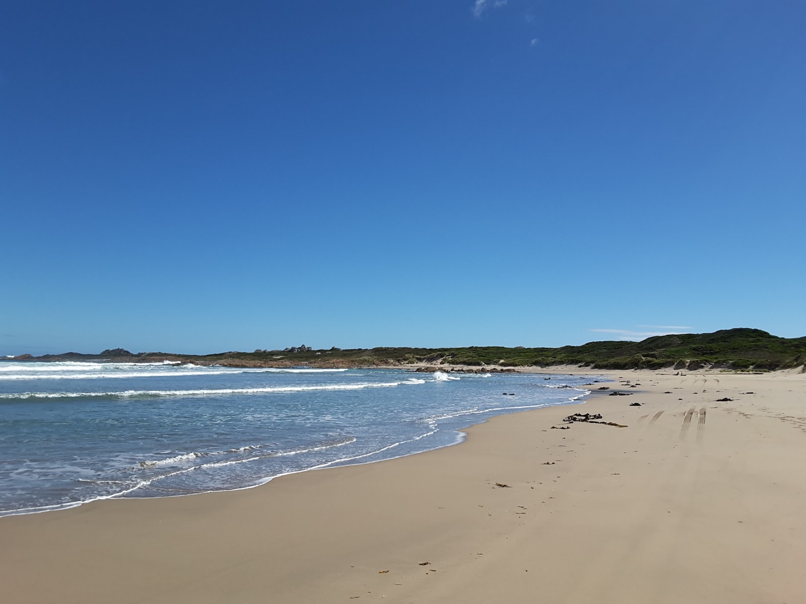 Foto van Lighthouse Beach met beige zand en stenen oppervlakte
