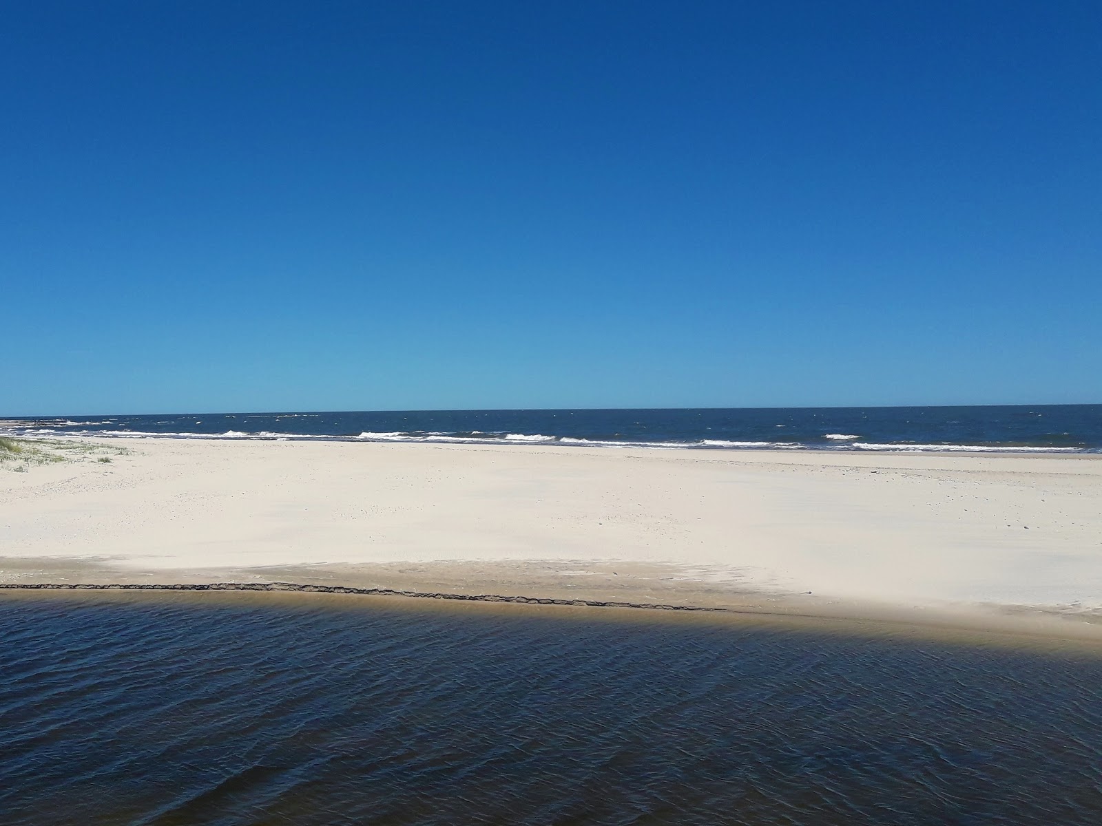 Foto van San Antonio Beach met helder zand oppervlakte