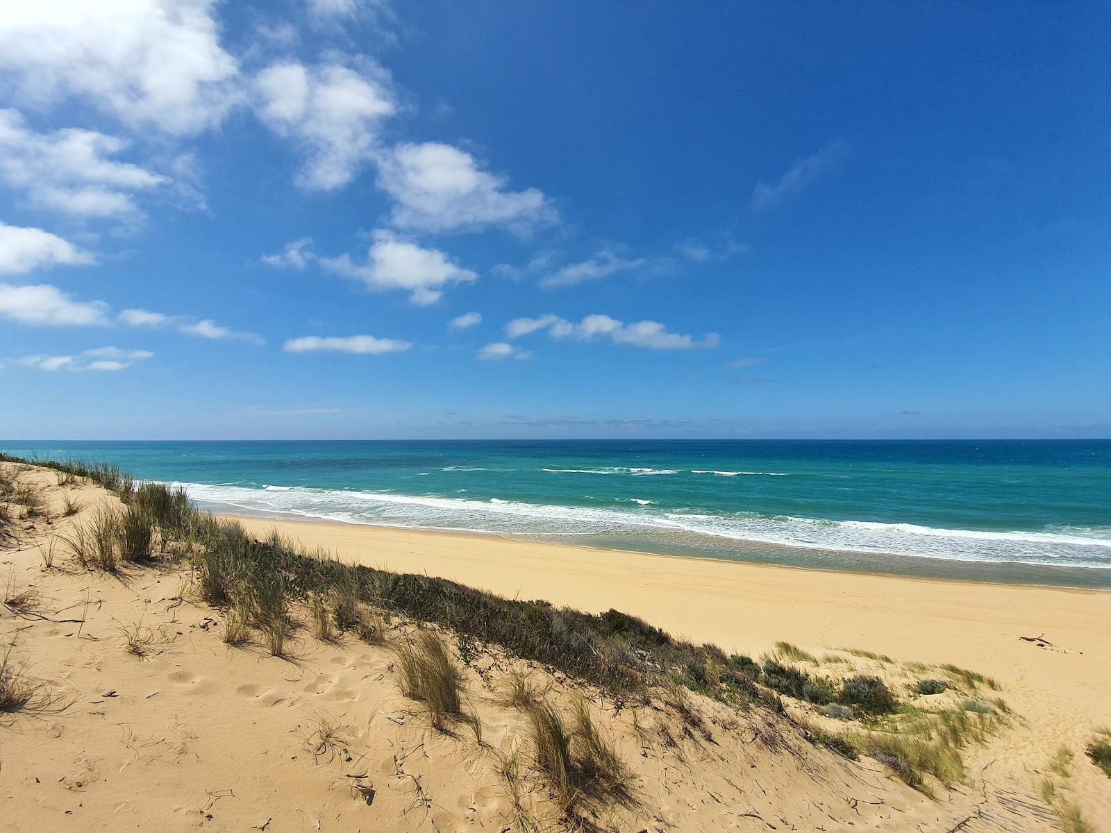 Foto van Corringle Beach met fijne beige zand oppervlakte