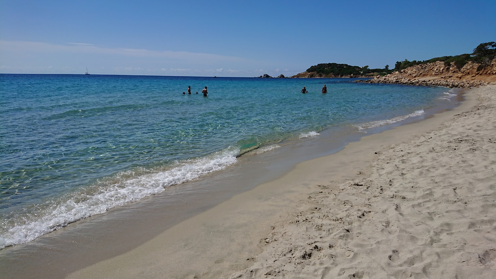 Foto av Spiaggia Is Piscadeddus omgiven av klippor
