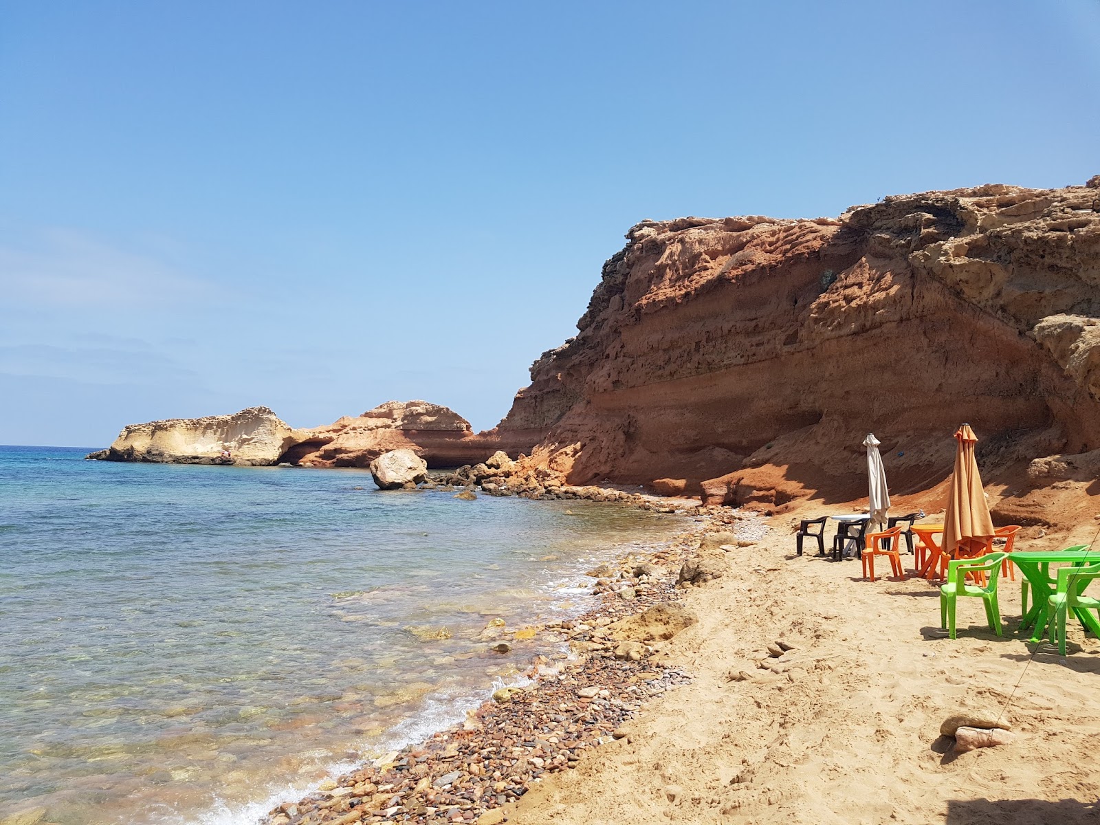 Foto av Red beach med turkos rent vatten yta