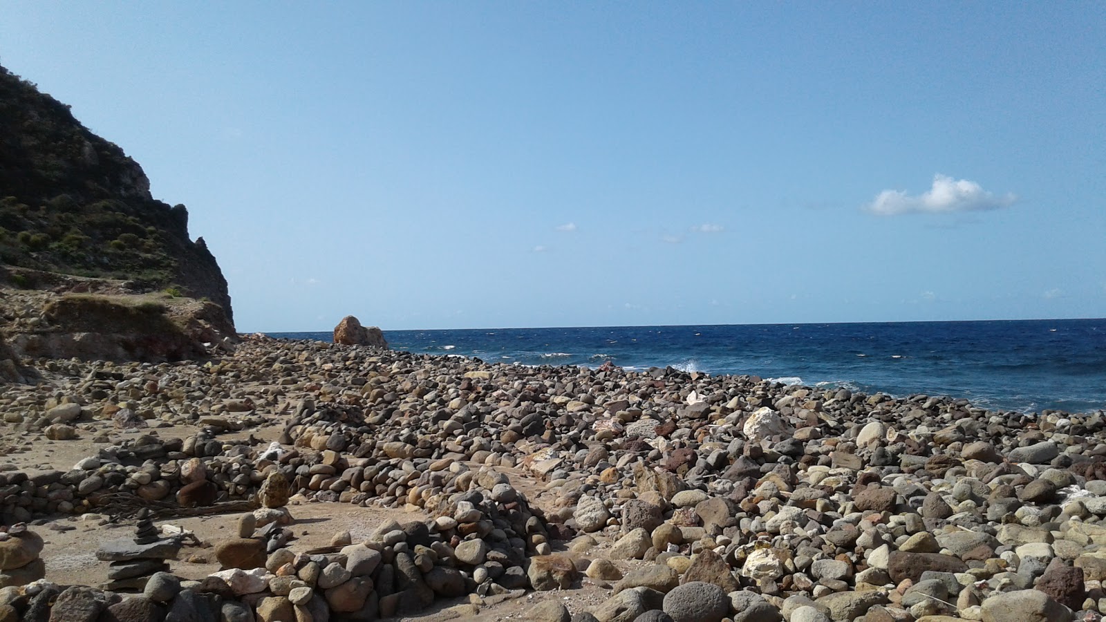 Foto av Calcara Beach omgiven av klippor
