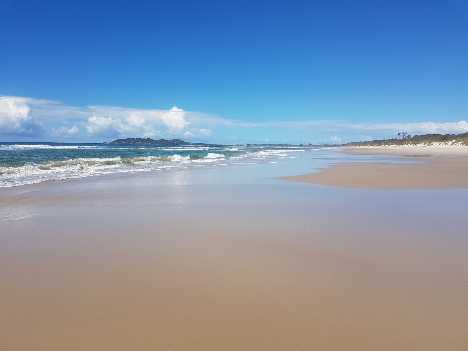 Φωτογραφία του Tyagarah Beach με φωτεινή άμμος επιφάνεια