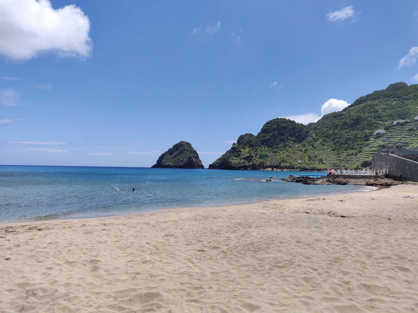 Foto af St. Lawrence Beach bakket op af klipperne