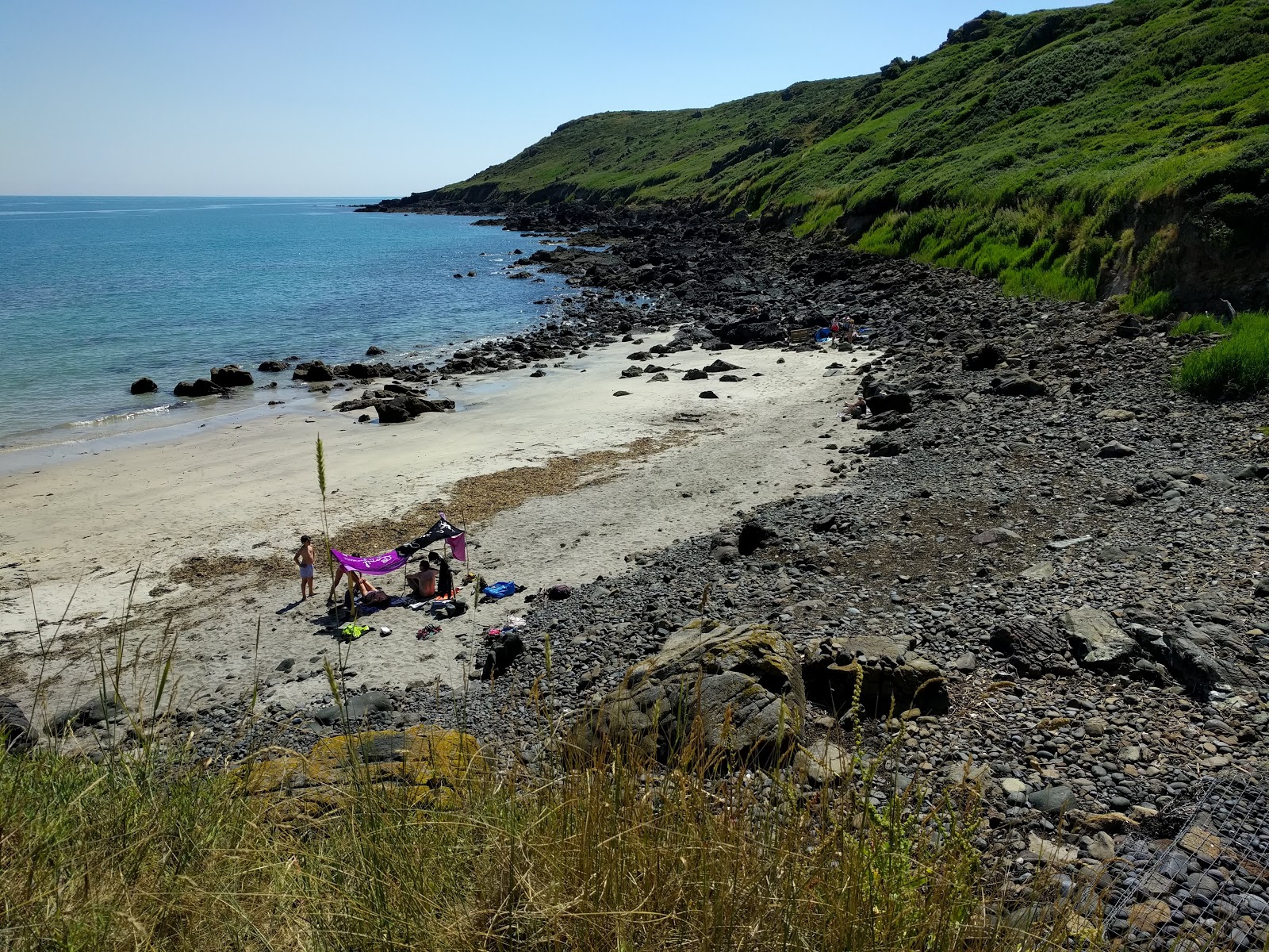 Foto von Porthbeer Cove mit beiger sand & steine Oberfläche