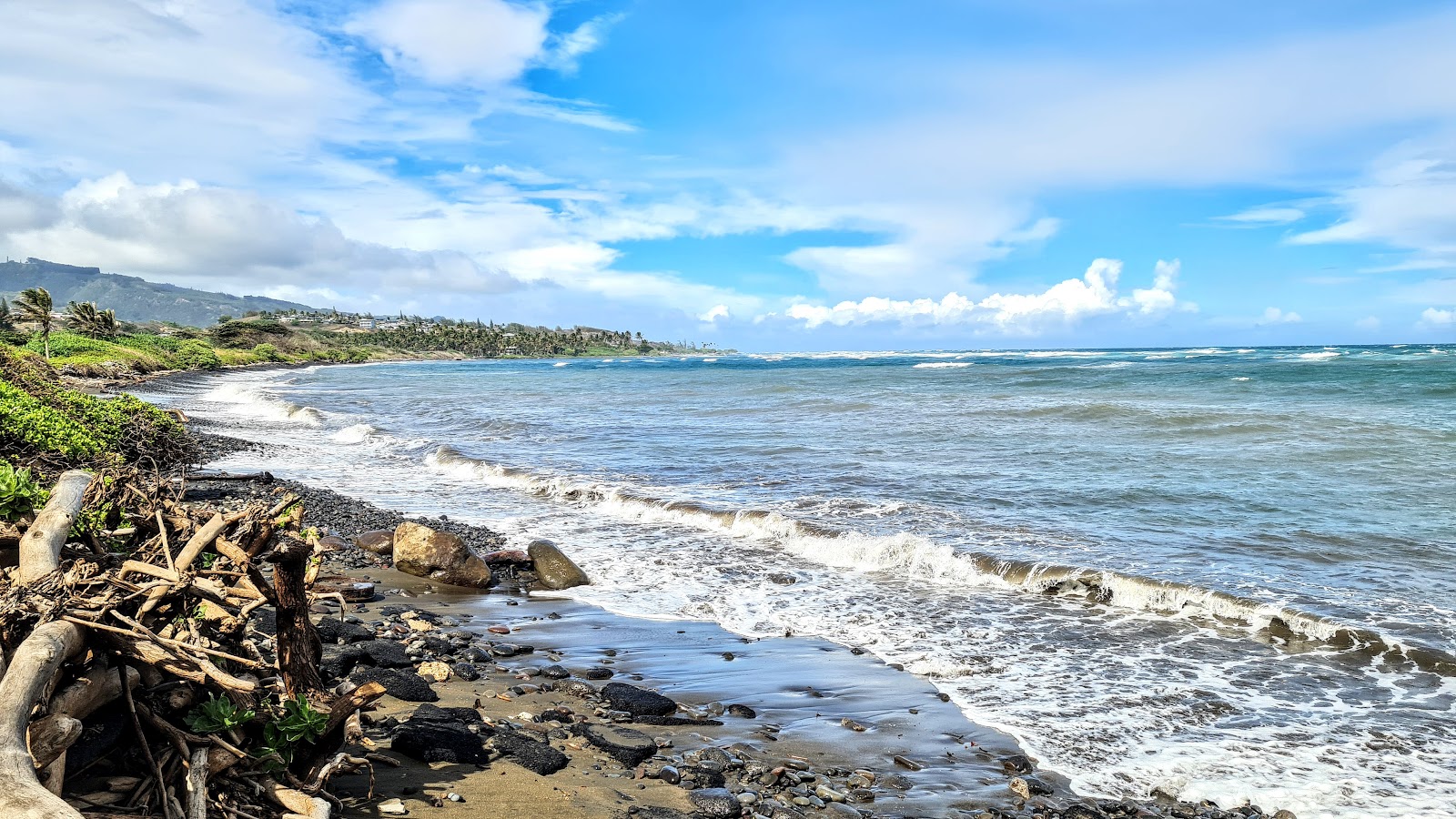 Foto van Paukukalo Beach met grijze kiezel oppervlakte