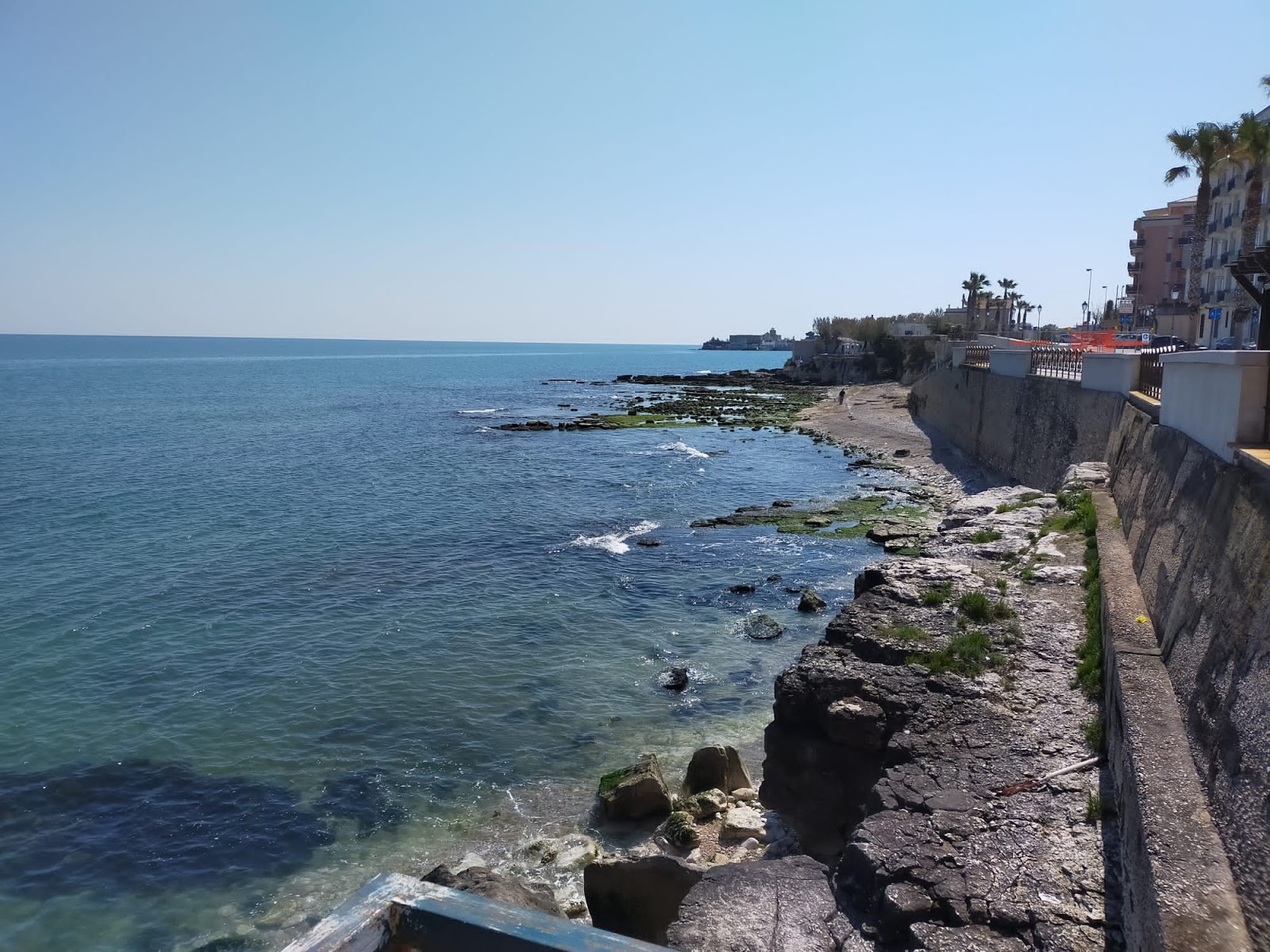 Foto de Rock of Frisio beach con arena gris y piedras superficie