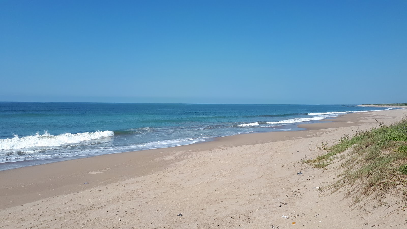 La Escopama beach的照片 带有碧绿色纯水表面