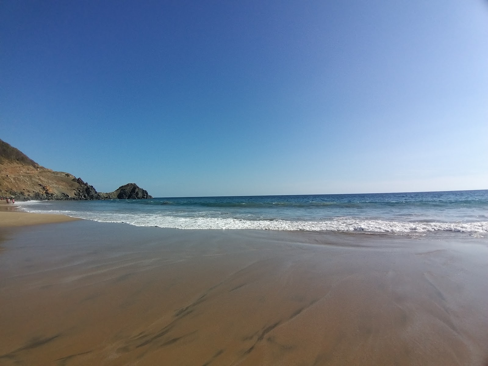 Photo de Playa Puerto Vicente avec sable fin et lumineux de surface