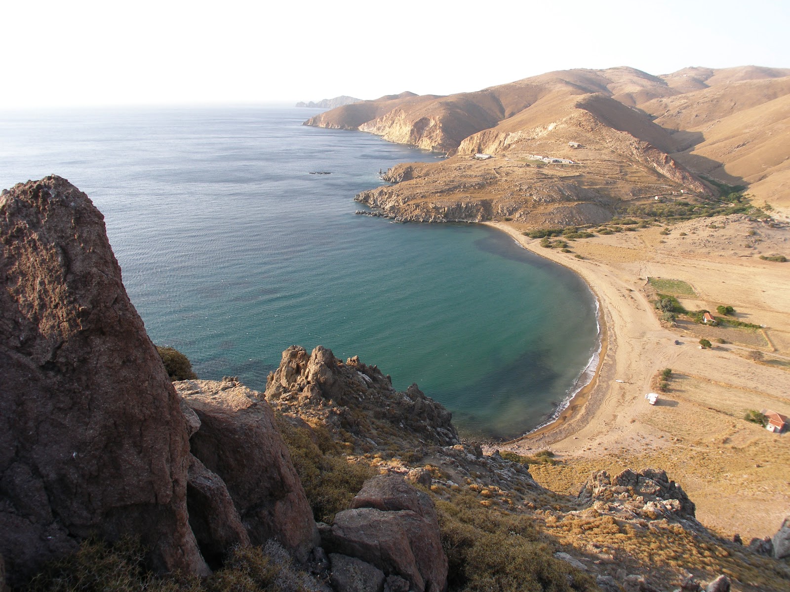 Photo of Paralia Karvoinolakas with brown sand &  rocks surface