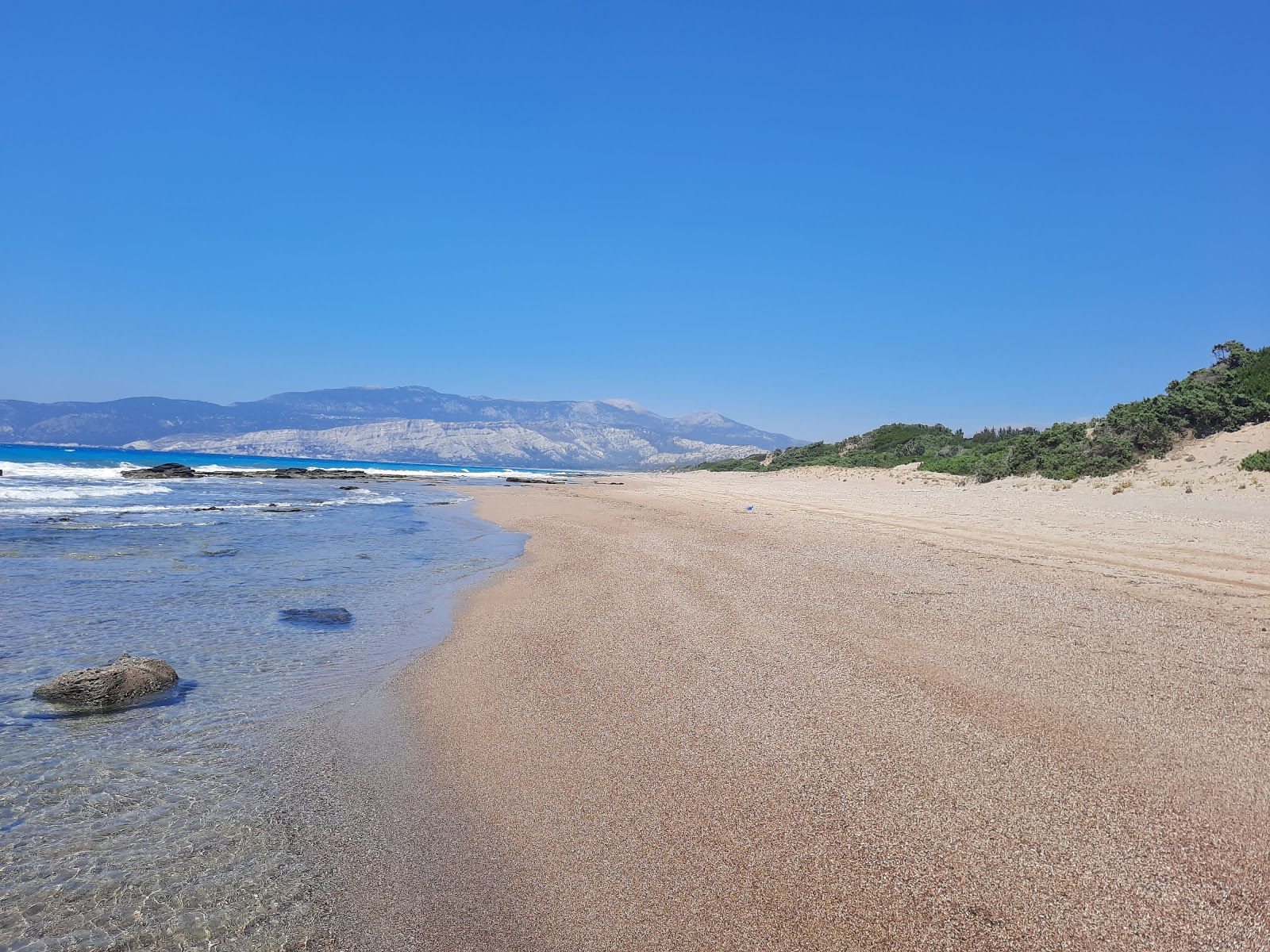 Fotografie cu Limni Beach cu o suprafață de nisip negru și pietricele