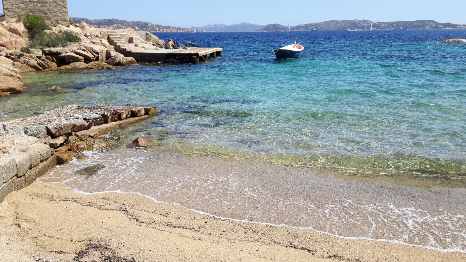 Foto di Spiaggia di Cala Martinella circondato da montagne