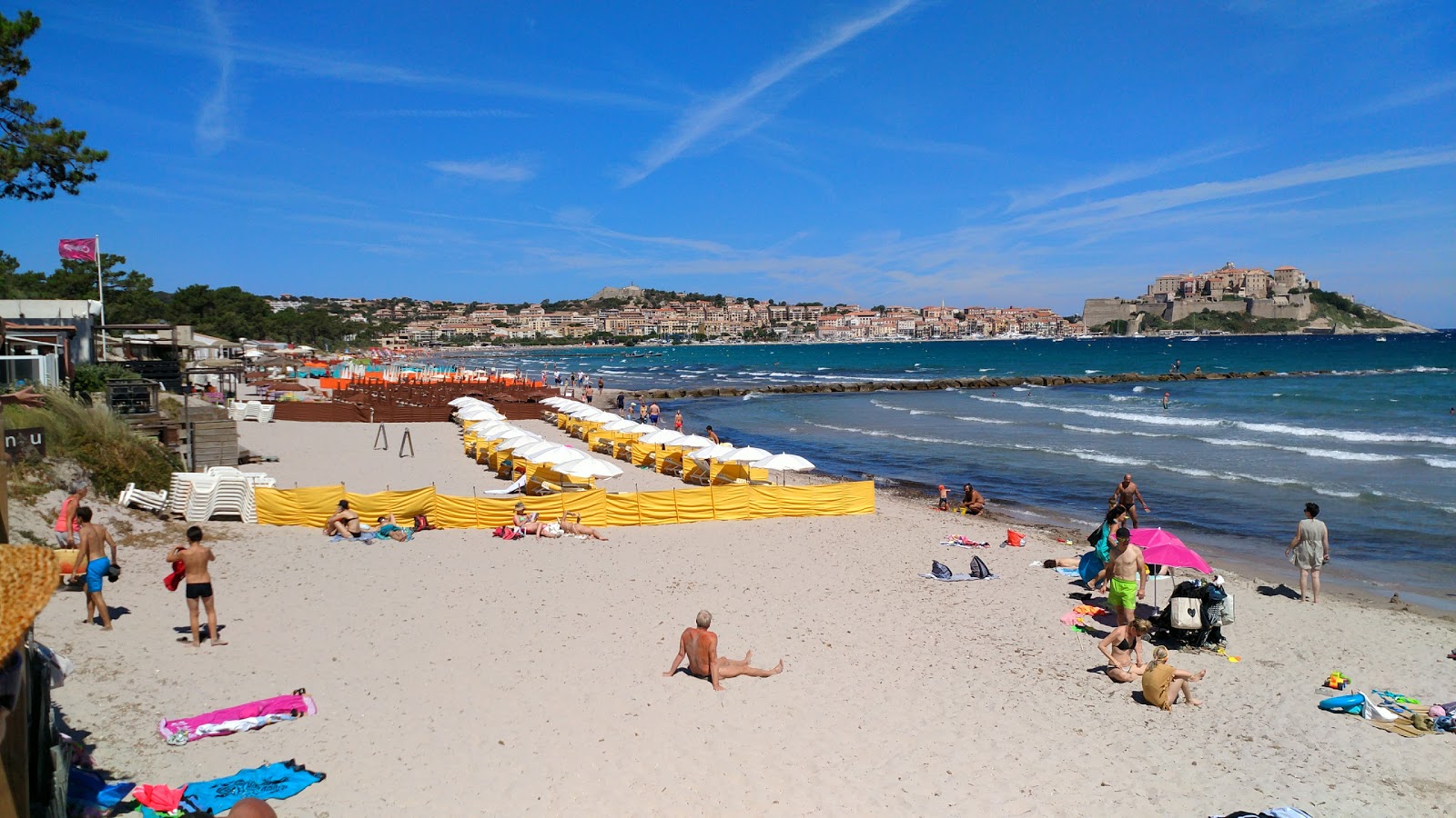 Valokuva Calvi beachista. pinnalla turkoosi puhdas vesi:n kanssa
