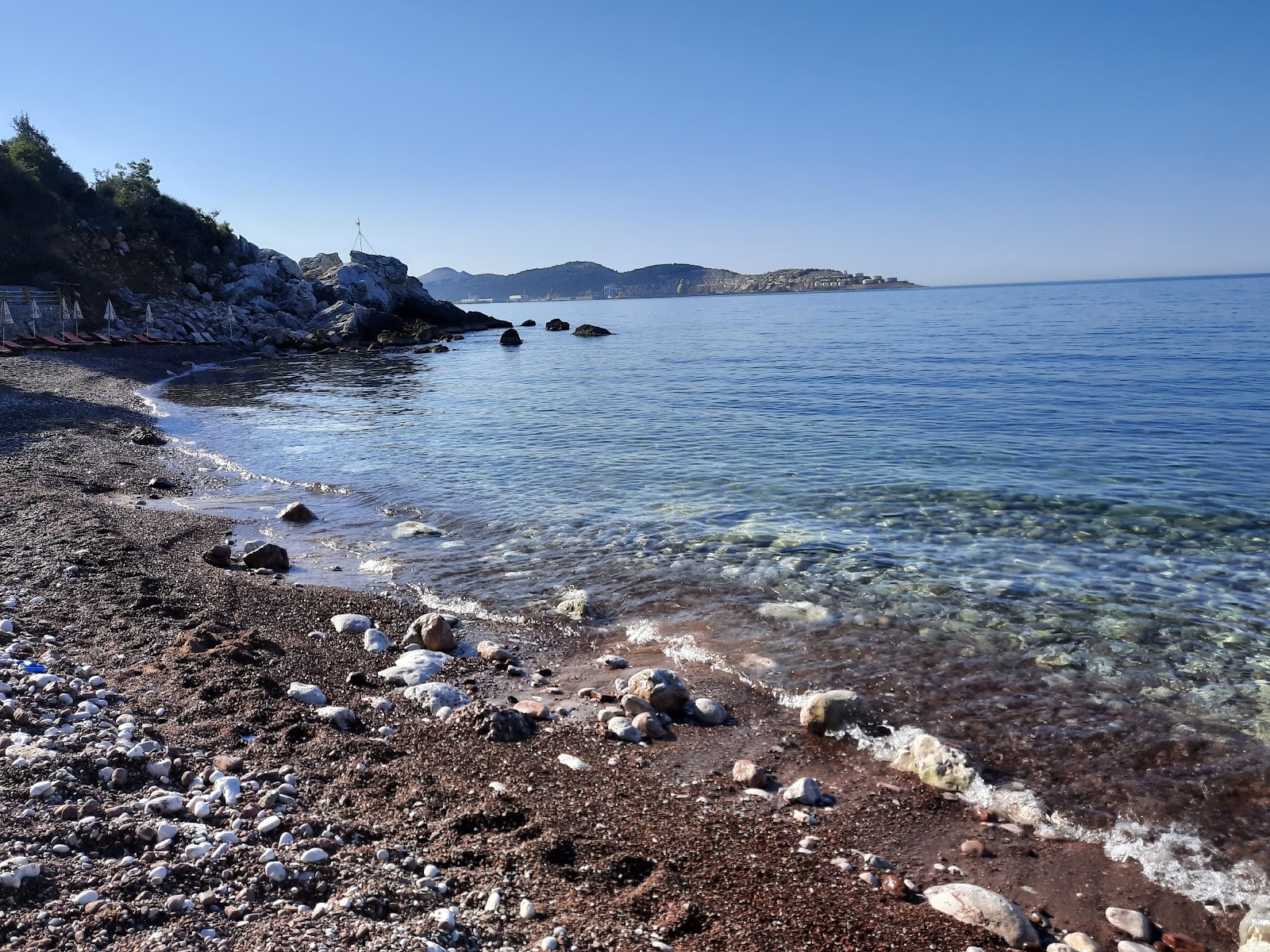 Red beach'in fotoğrafı uçurumlarla desteklenmiş