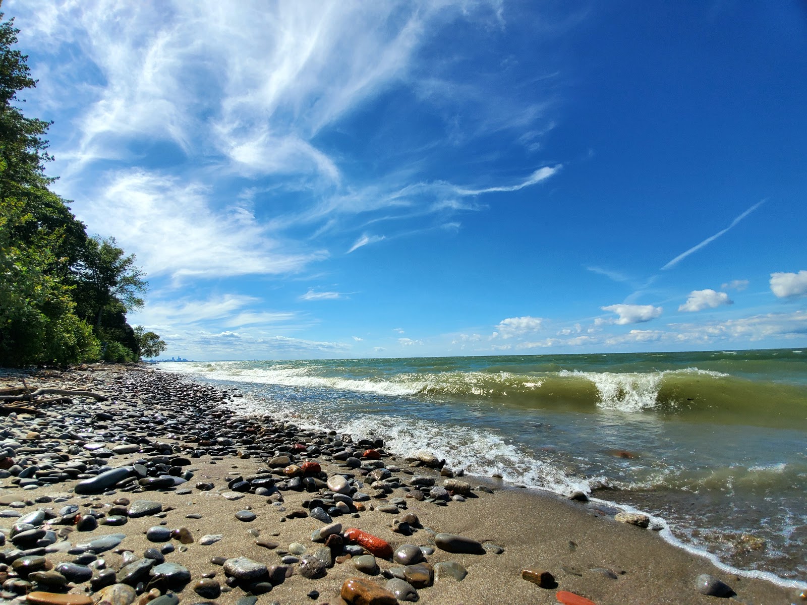 Fotografie cu Arcadia Beach cu o suprafață de nisip beige și pietre