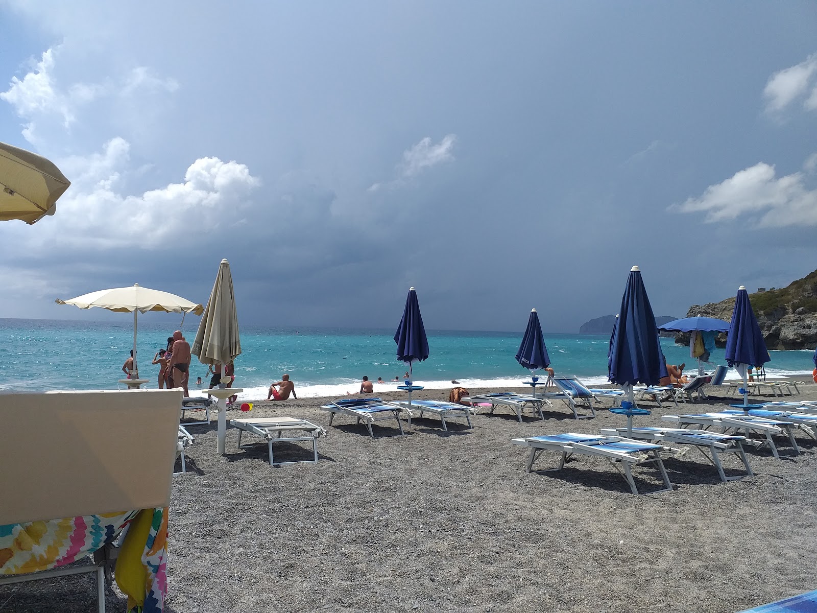 Foto av Spiaggia di Capogrosso omgiven av berg