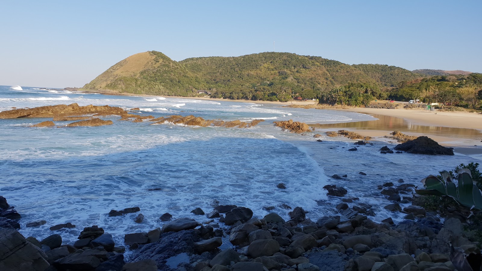 Foto af Port St Johns II bakket op af klipperne