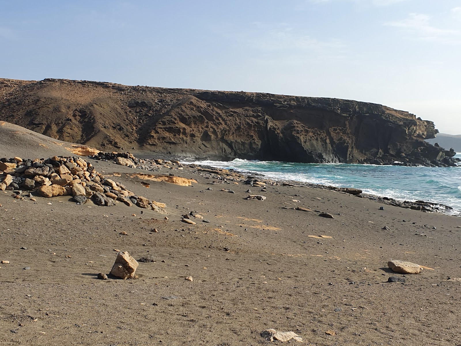 Fotografie cu Playa de la Pared cu o suprafață de nisip maro și roci