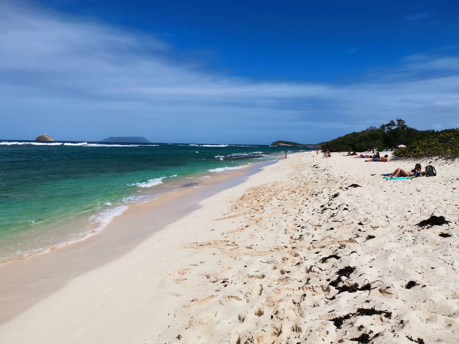 Foto de Plage d'Anse a la Gourde com linha costeira longa e reta