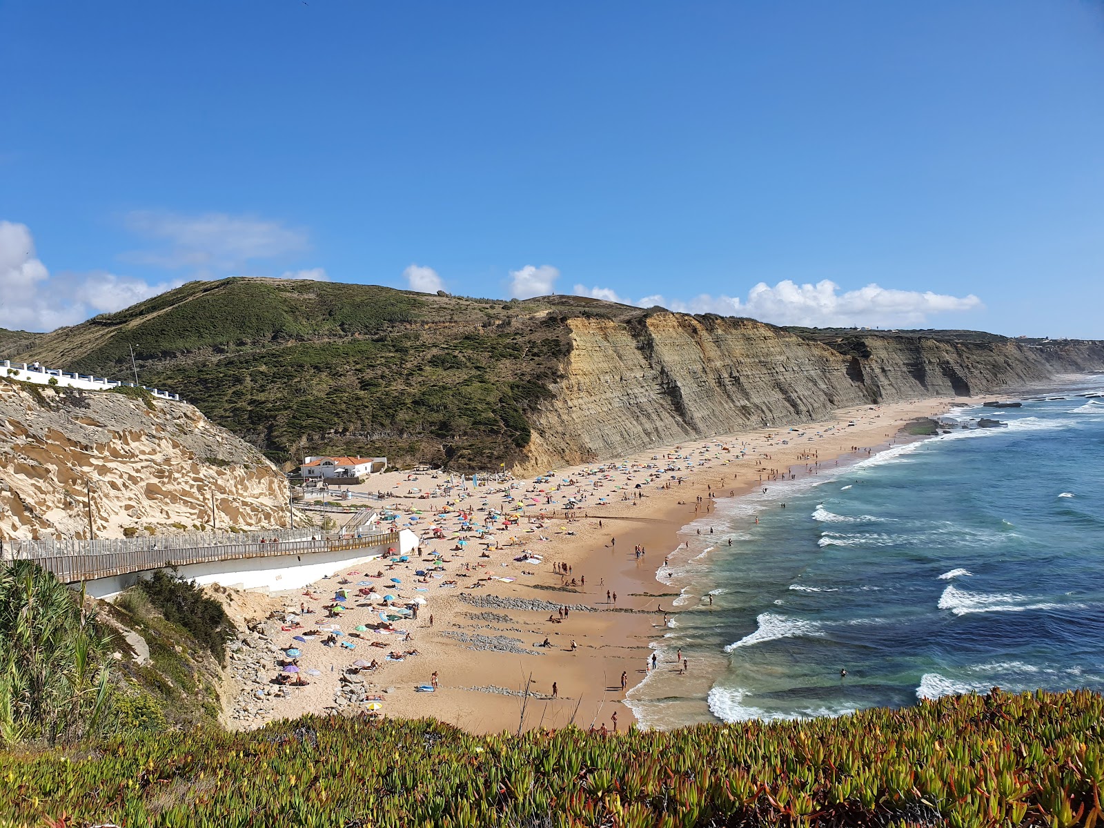 Foto di Praia do Magoito con una superficie del sabbia beige fine