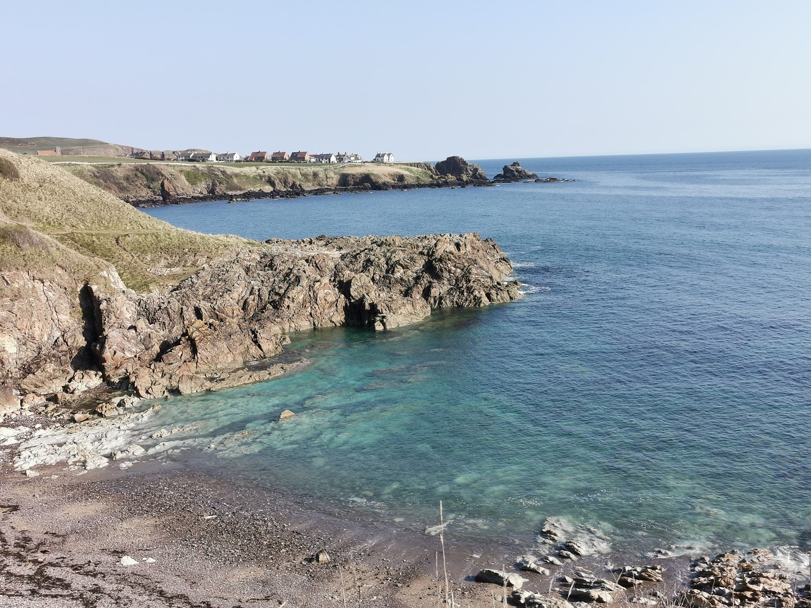 Fotografija Milldown Bay Beach z sivi kamenček površino