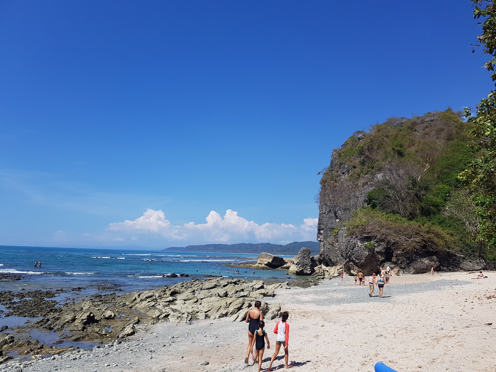 Foto di Playa Cuevas con una superficie del sabbia beige e rocce