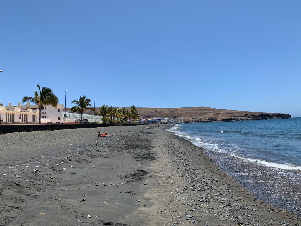 Foto av Playa negra Tarajalejo med harmaa hiekka ja kivi yta